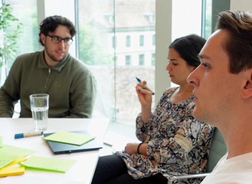 Das Team von Epic Fusion gemeinsam an einem Arbeitstisch im Coworking Space zentroom