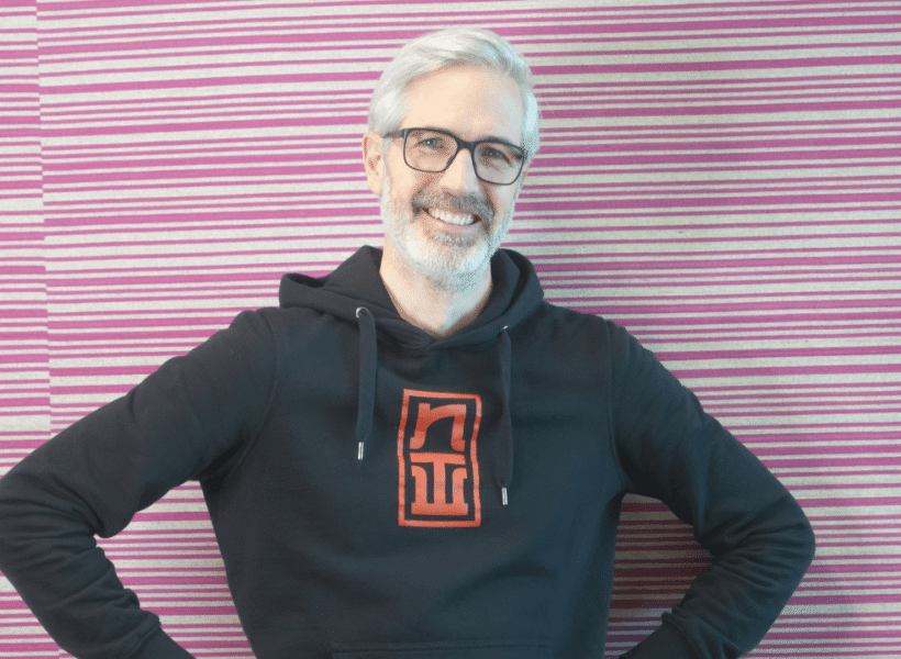 Porträt von Michael Bridge, Teammitglied von zentroom, vor einem modernen Coworking Space-Hintergrund.